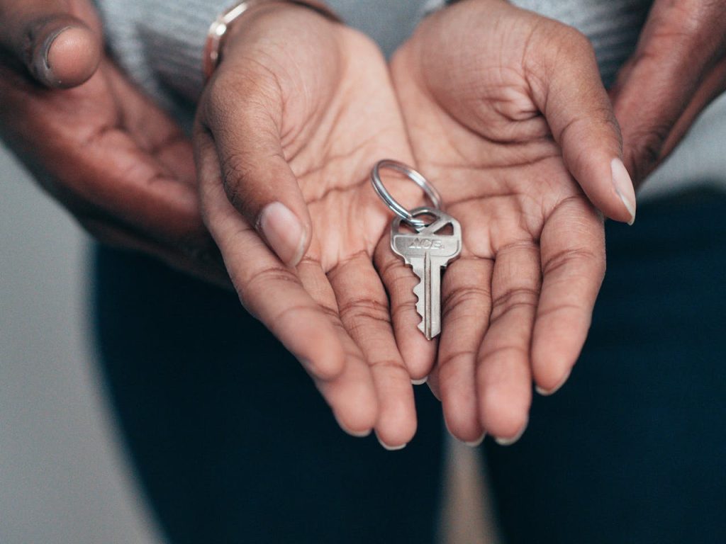 Close-up of hands holding a key, symbolising homeownership, real estate, and property investment